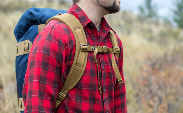 A 3/4 shot of a person using a Guide's Pack with the sternum strap buckled.